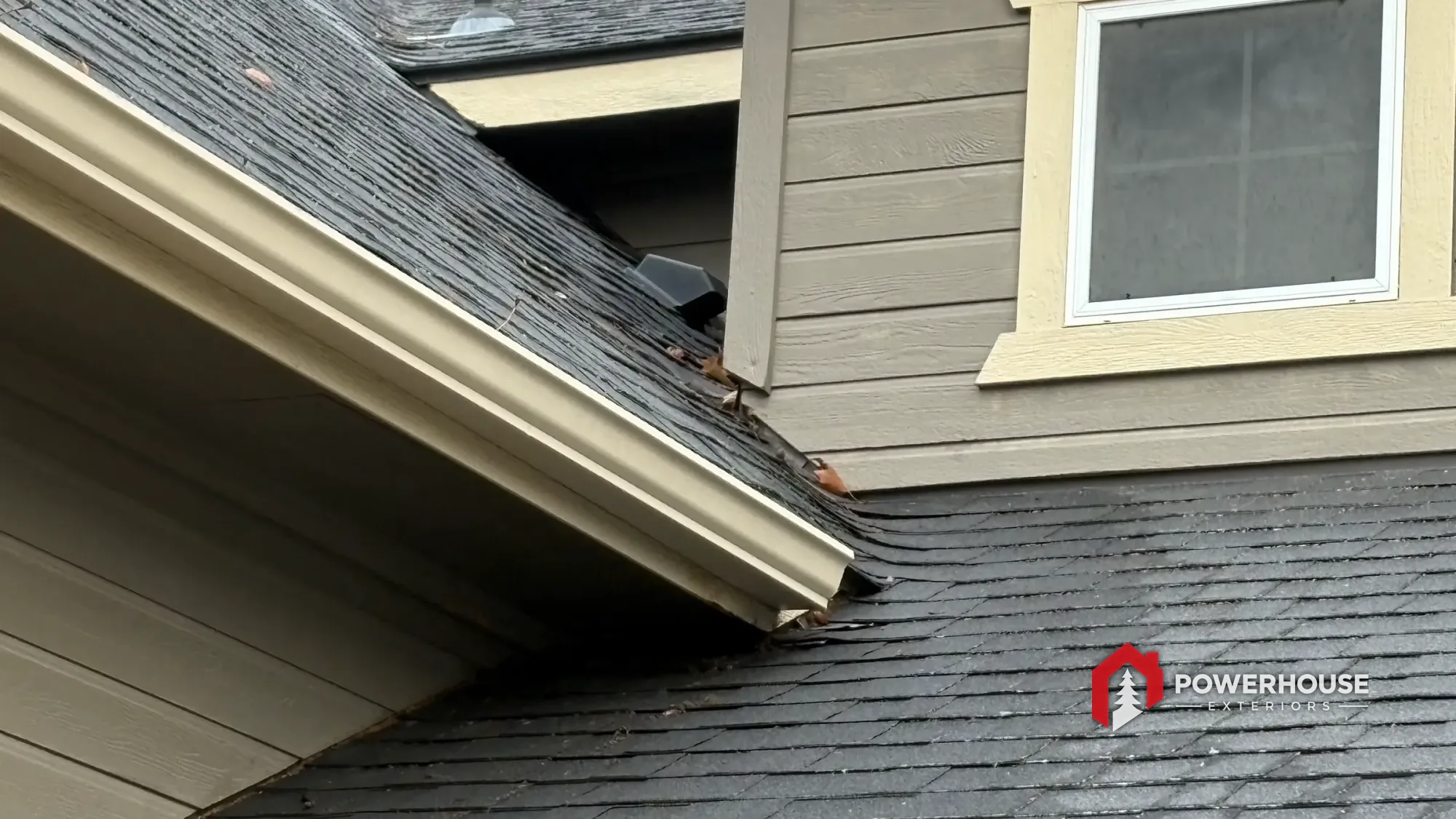 A weathered residential roof valley and wall intersection on a Treasure Valley home — the kind of wear a storm can turn into a claim.