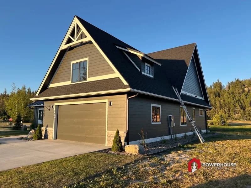 Garage-side elevation showing shingle roof planes and metal accent transition