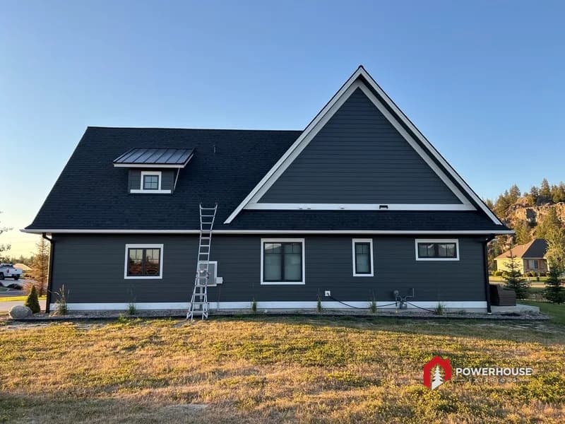 Rear elevation with a standing-seam metal dormer accent above the shingle field