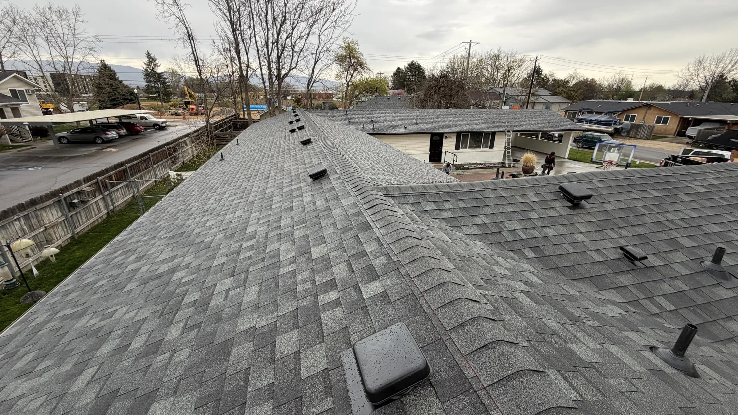 Completed architectural shingles and ridge caps on a Boise multifamily roof