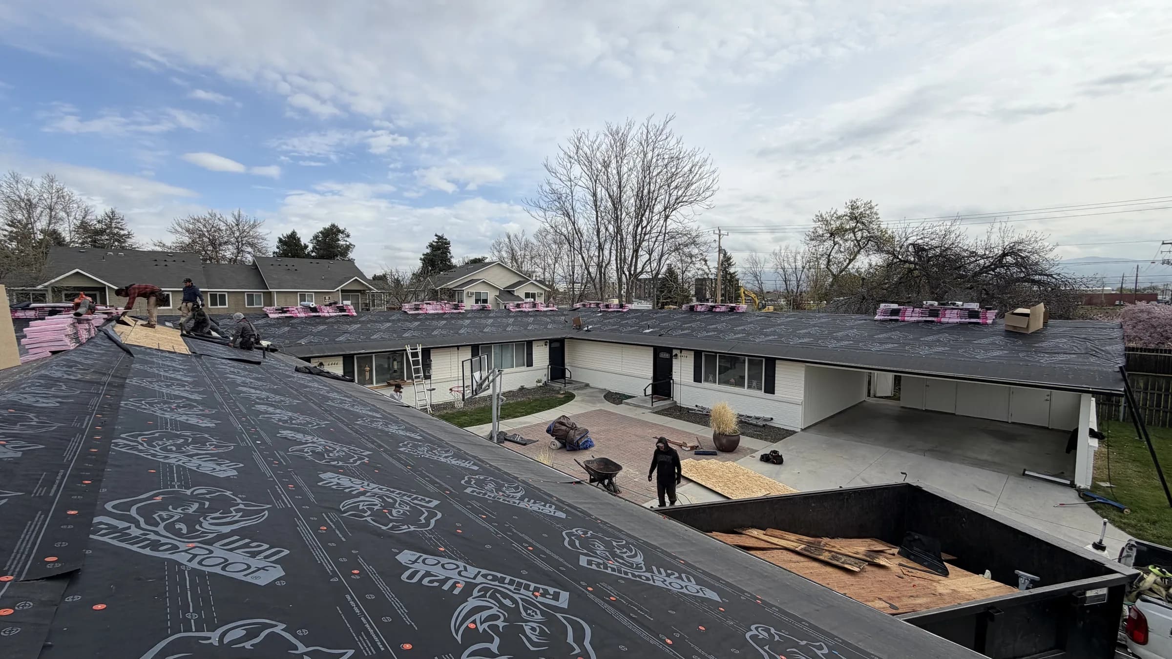 Roofing crew preparing underlayment and decking repairs on a Boise multi-unit roof