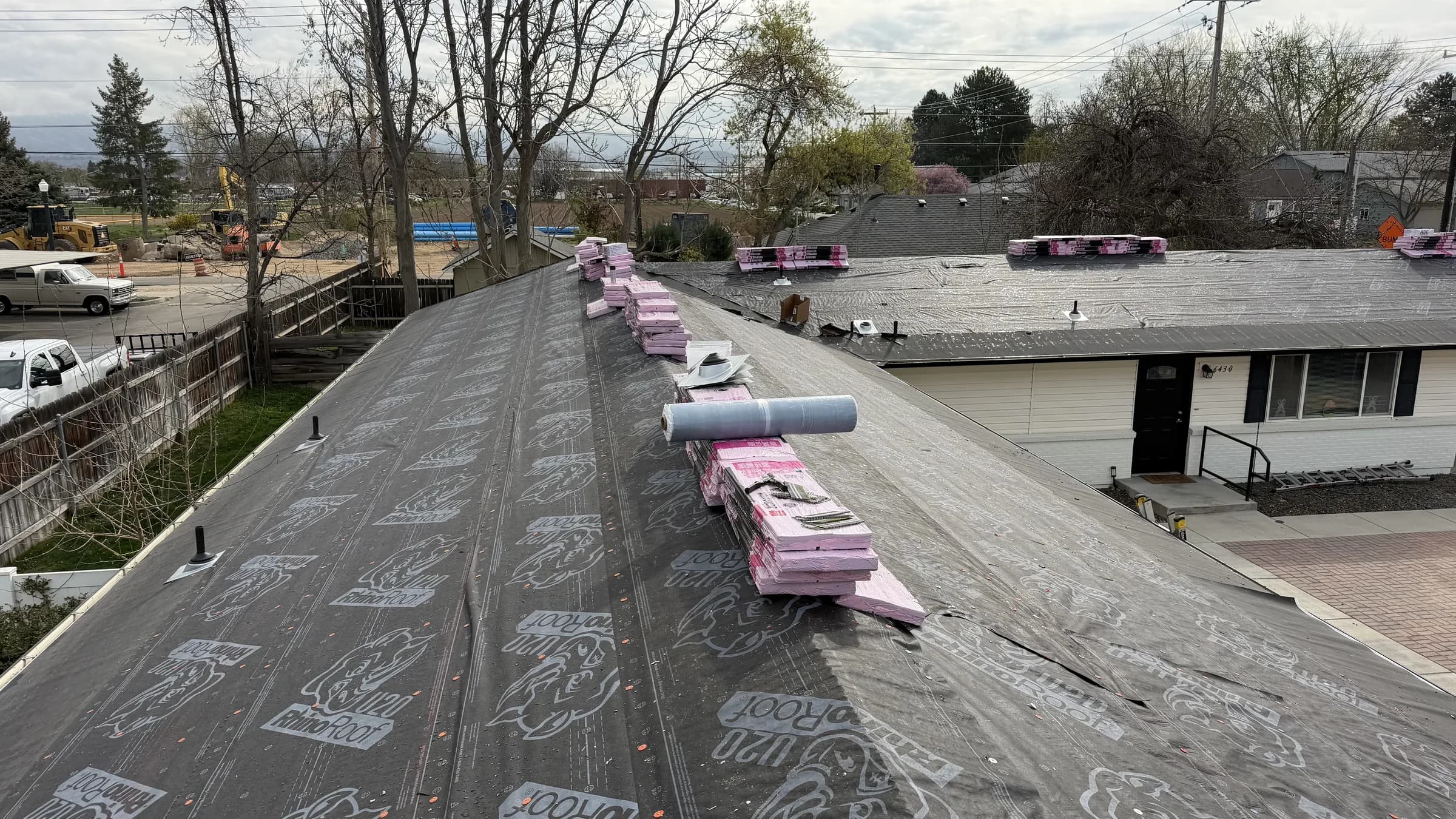 Roofing materials staged over synthetic underlayment on a Boise multifamily property