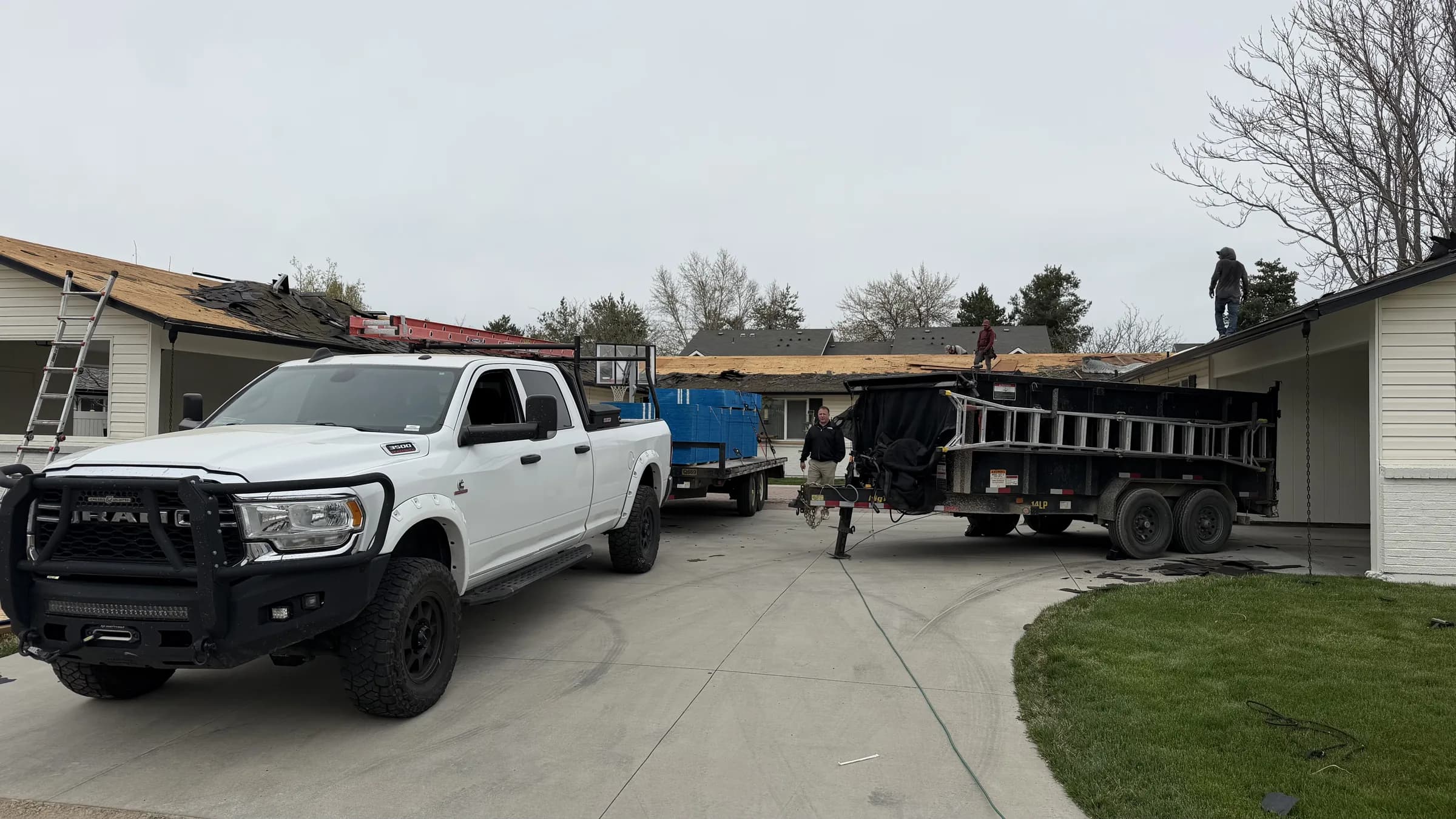 Roofing crews removing shingles from multiple connected units in Boise