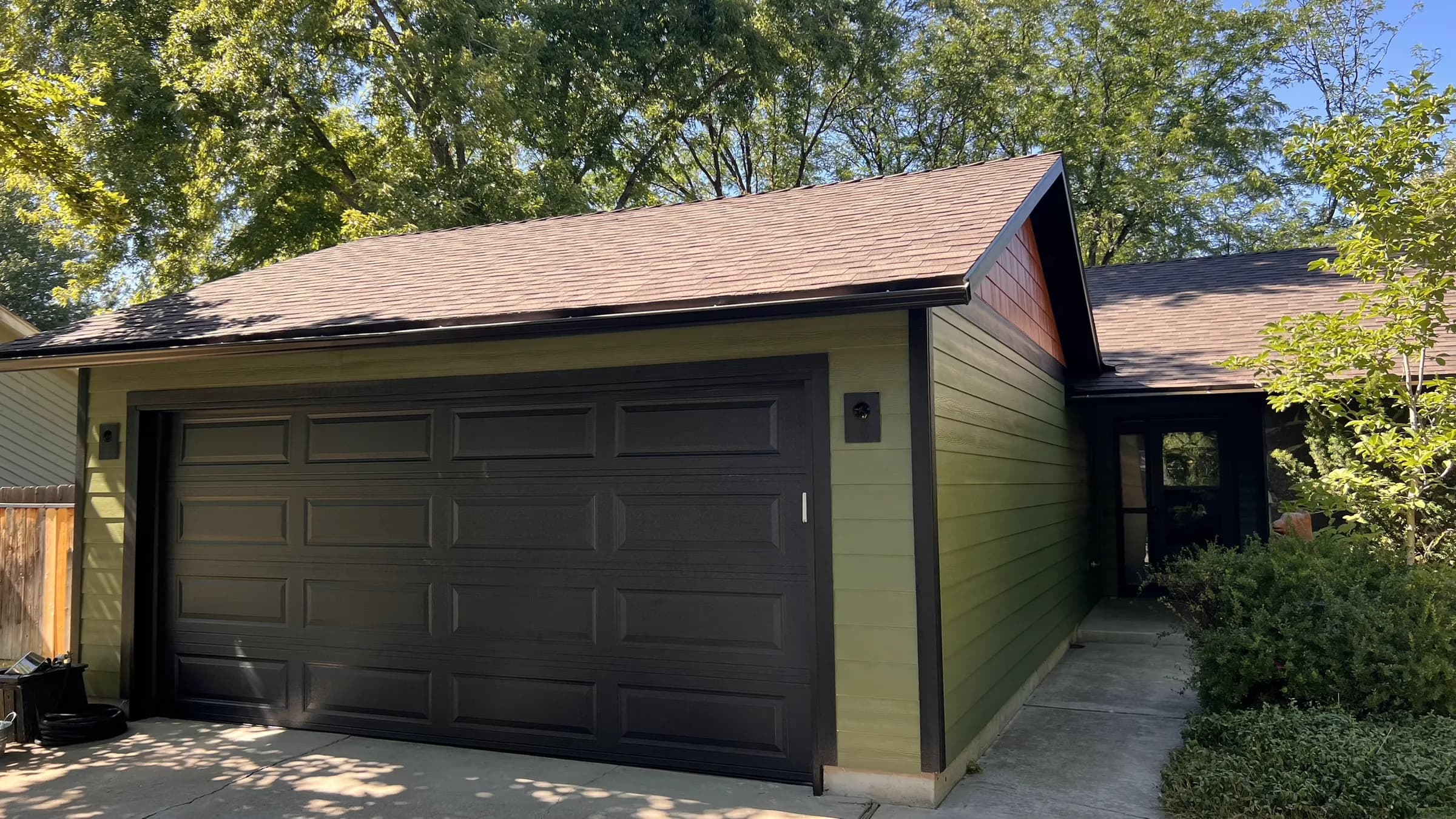 Completed Boise roof with green lap siding and dark garage trim