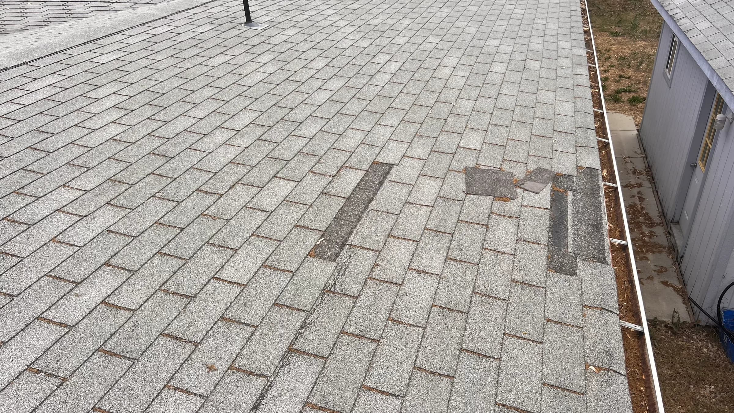 Patched and aging asphalt shingles before replacement on a Boise residence