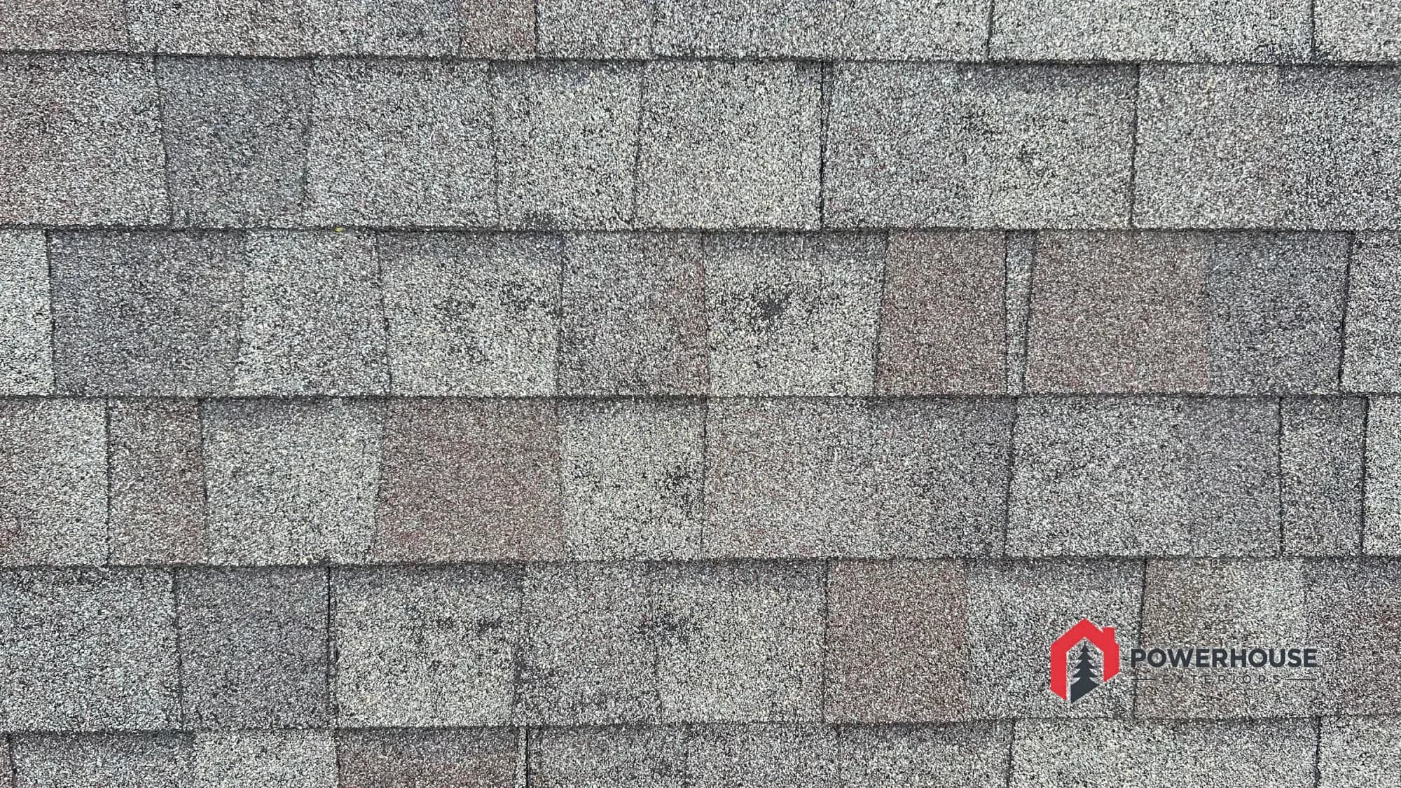 Close view of shingles being examined for possible hail impact and granule loss