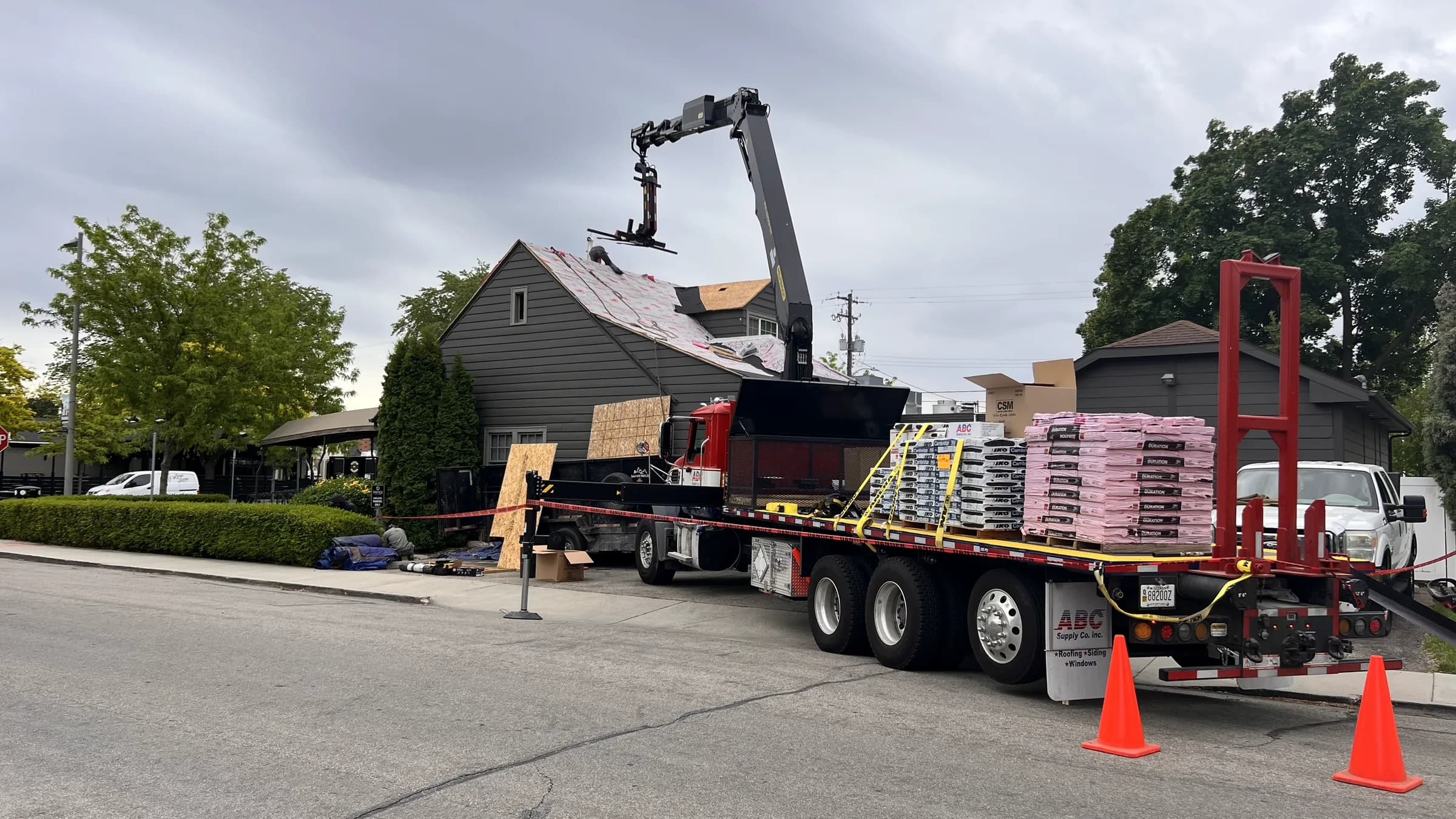 Commercial roofing materials delivered by crane for the Vintage 61 roof replacement