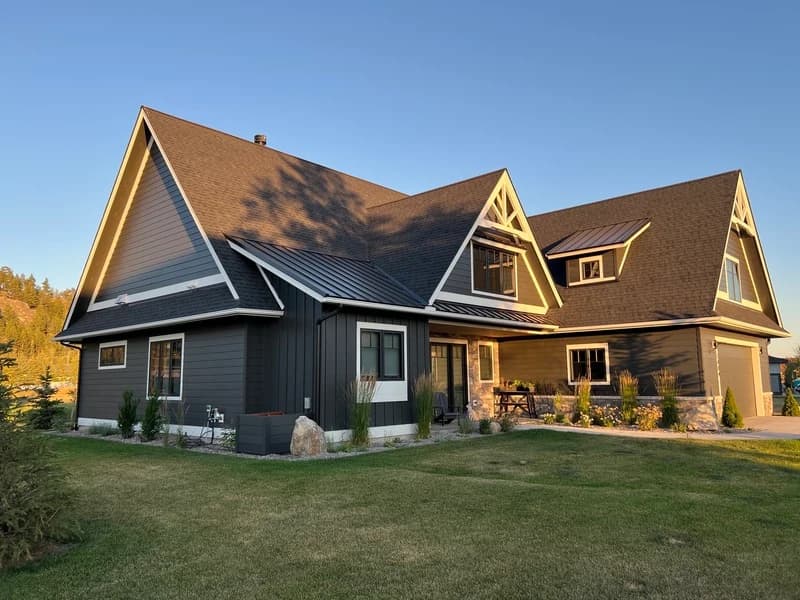 A completed dark craftsman home with asphalt shingle and standing-seam metal roofing built by PowerHouse Exteriors.